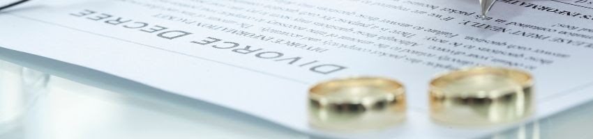 A pair of wedding rings over a divorce application symbolizing filing for divorce.