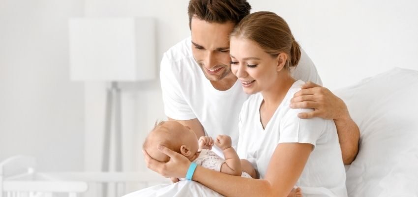 The couple is happily holding their newborn child.