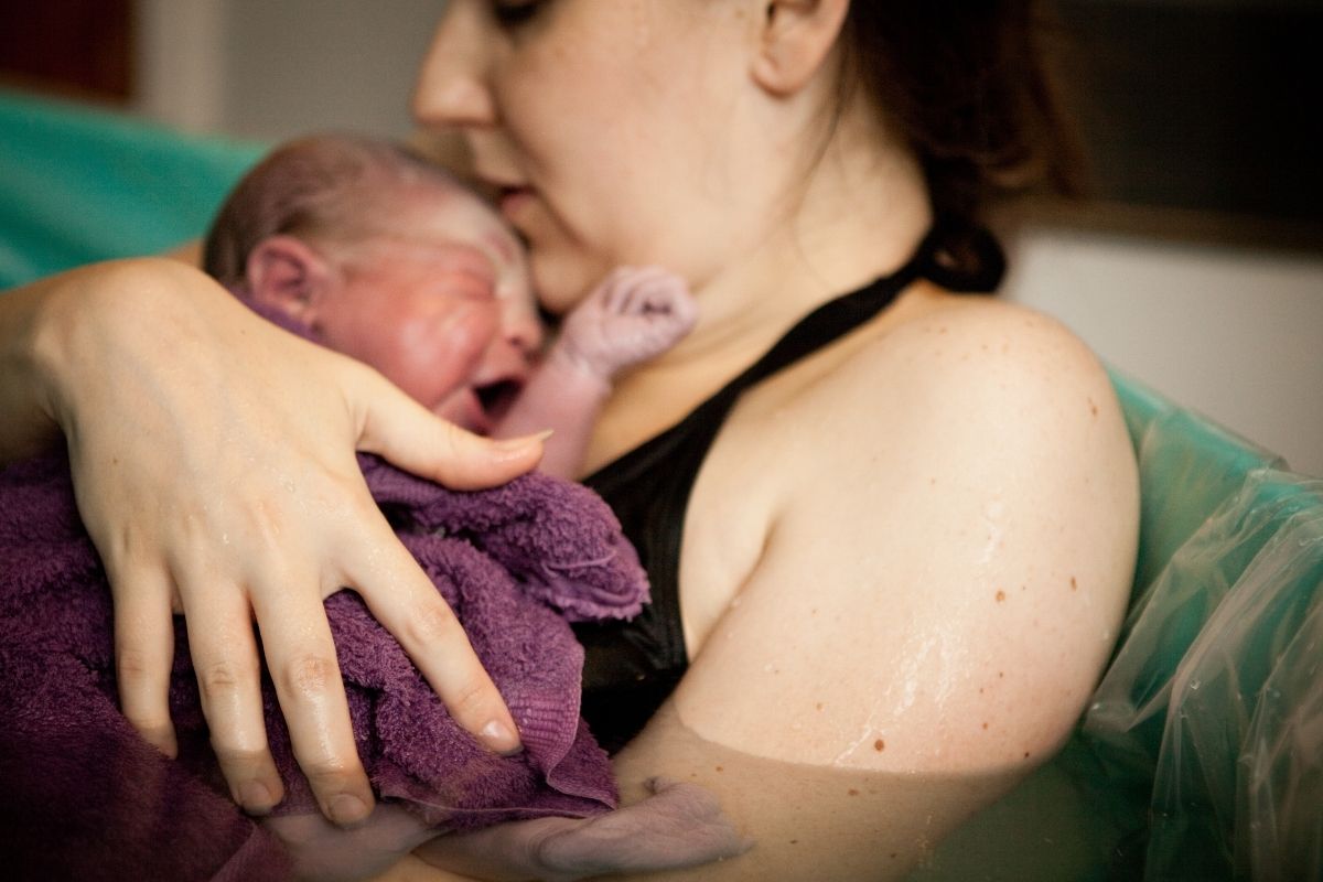A mother holding a newborn baby thinking about filing a birth injury lawsuit.