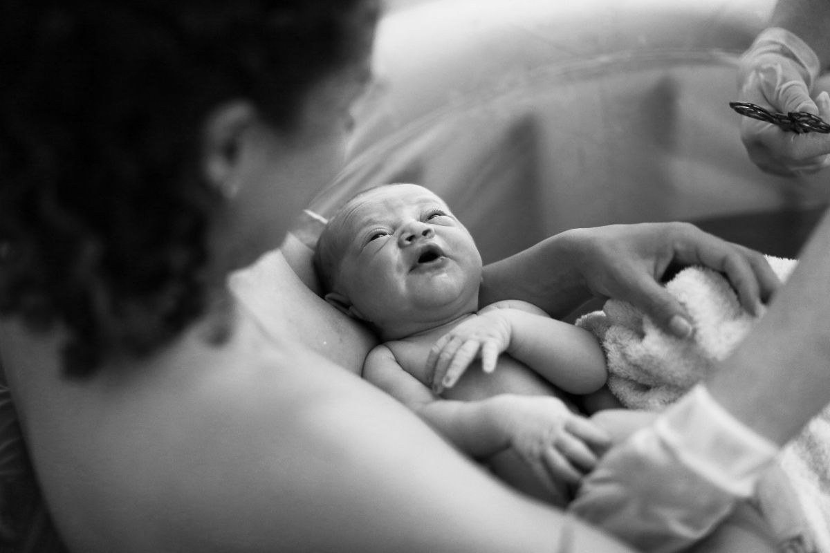 A woman looking at her newborn baby.