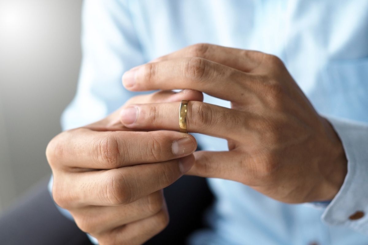 A man holding his wedding band while thinking about getting an annulment in Indiana.