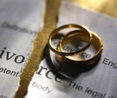 A divorce certificate with two wedding bands atop it.