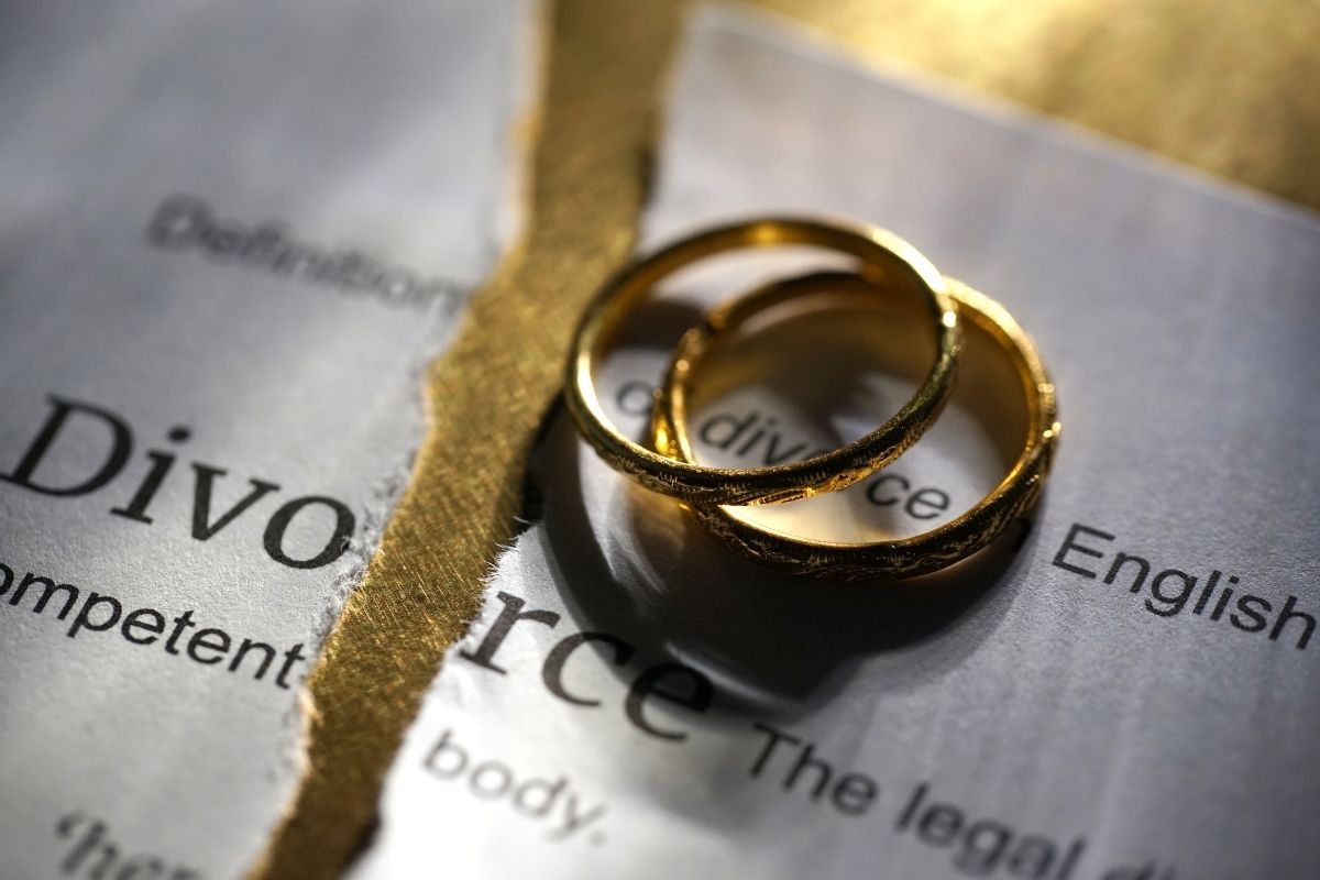 A divorce certificate with two wedding bands atop it.