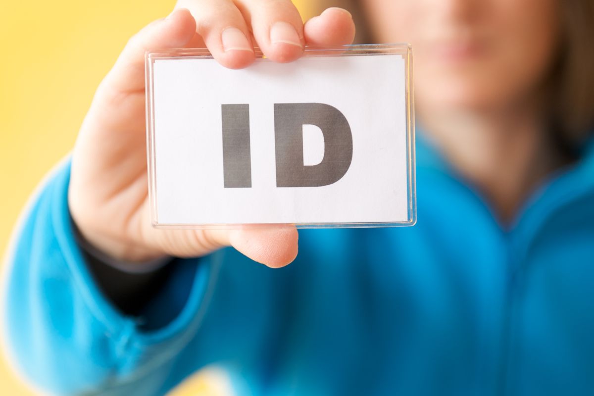 A man showing a card with the words ID on it.