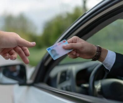 A man handing out his drivers license to someone.