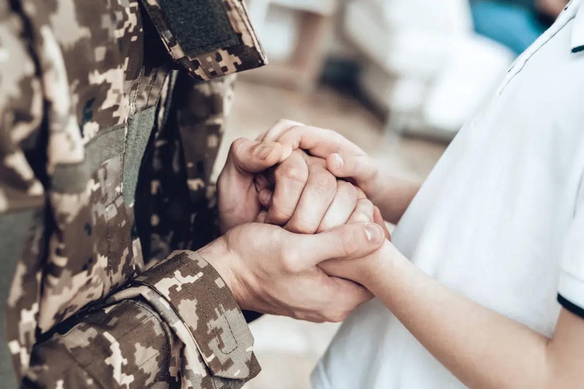 A military personnel holding hands with his wife.