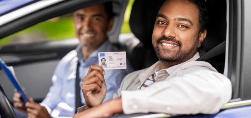 A man proudly showing off his drivers license.