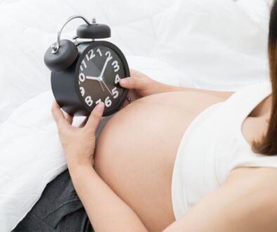 The pregnant woman checks the time and wonders when her first child will be born.