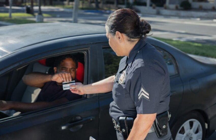 The police woman checks the drivers permit of the driver.