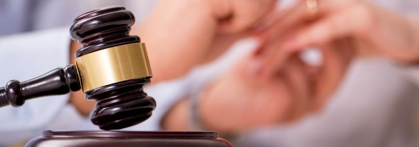 A gavel with a background of a couple's hand putting a ring for the common law marriage